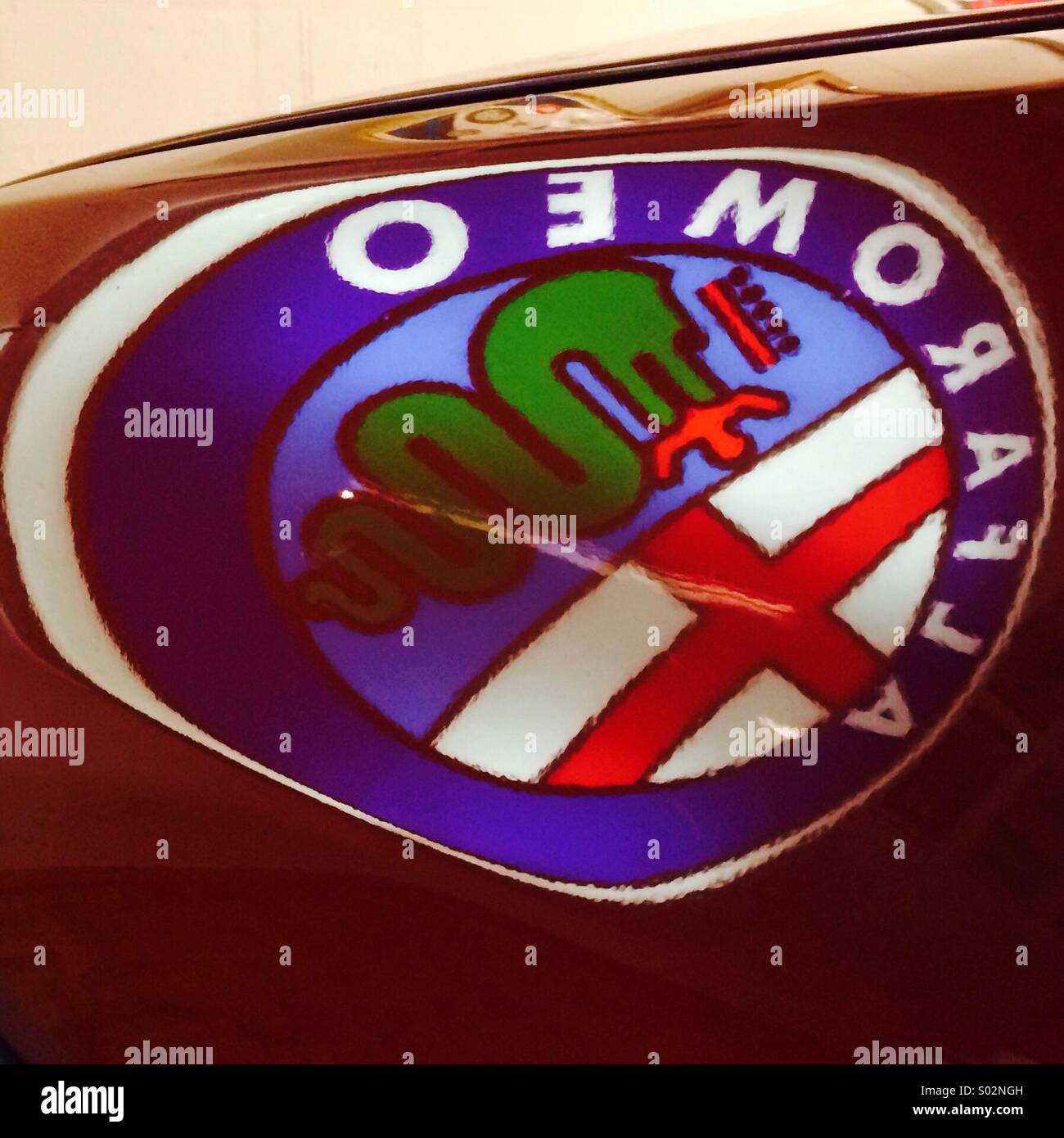Alfa Romeo logo sul riflesso altamente lucido cofano della macchina Foto Stock