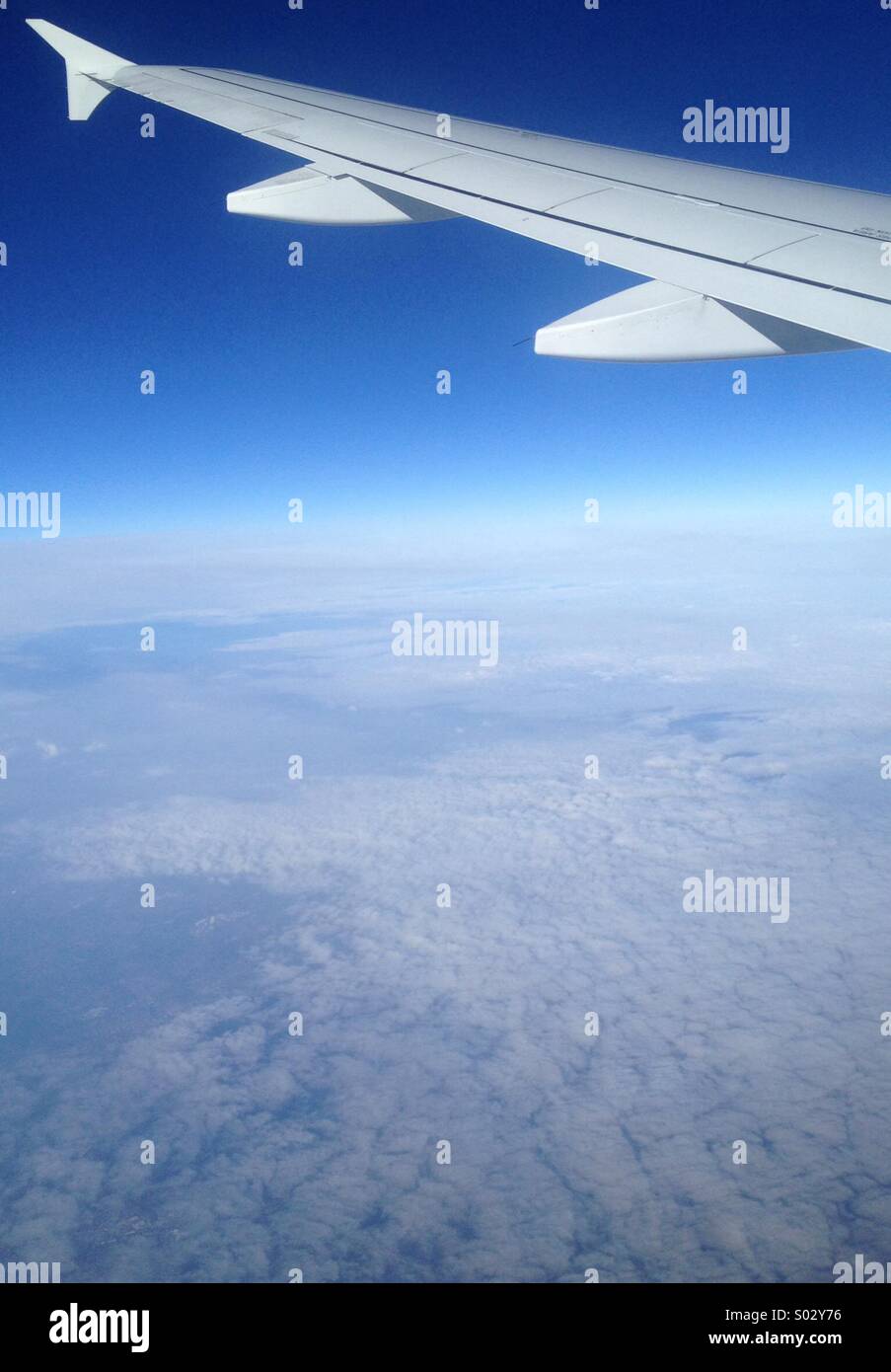 Ala di aeroplano visto dalla finestra di piano, volare sopra le nuvole Foto Stock