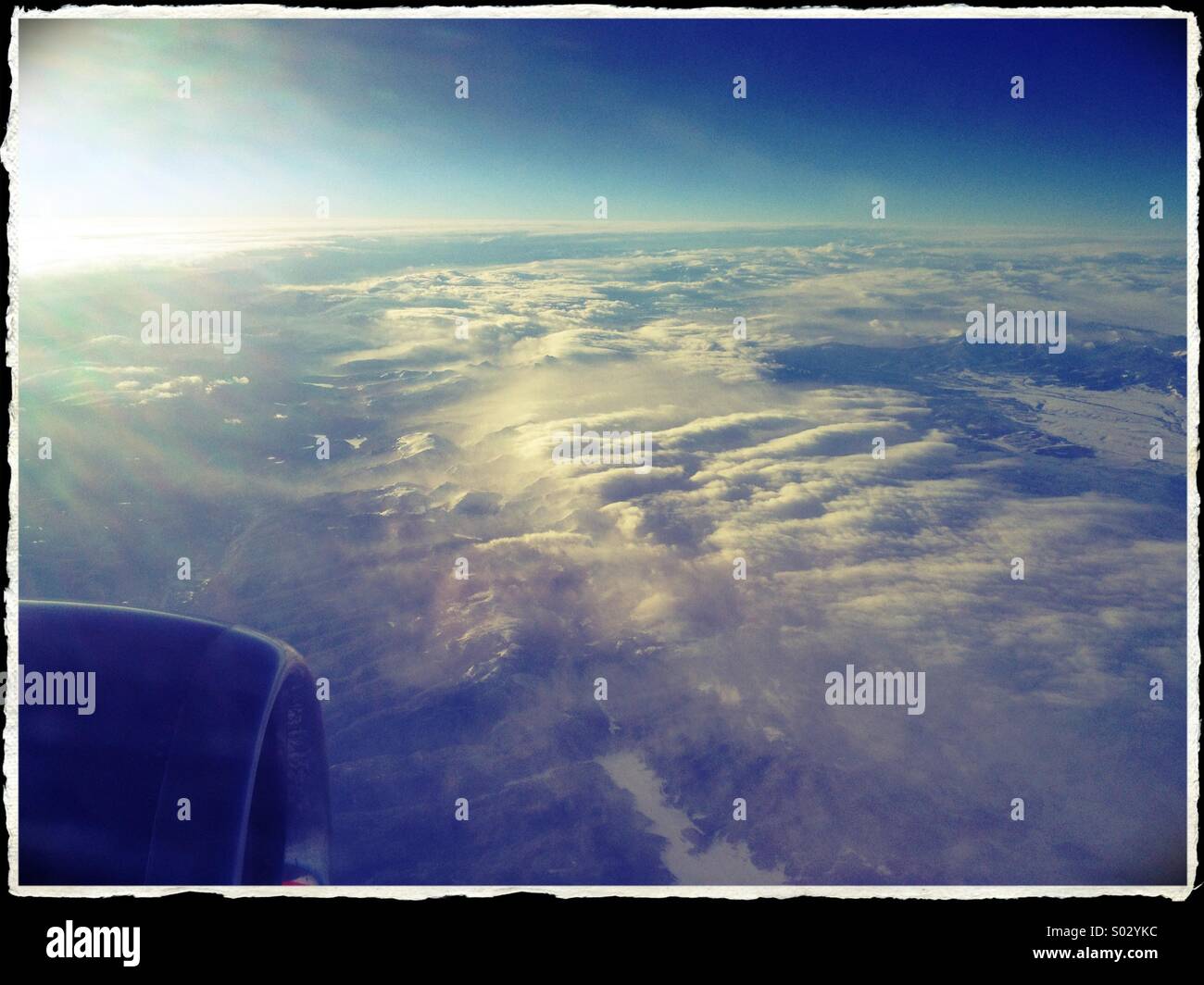 La vista di nuvole al di sotto, da un aeroplano finestra. Foto Stock