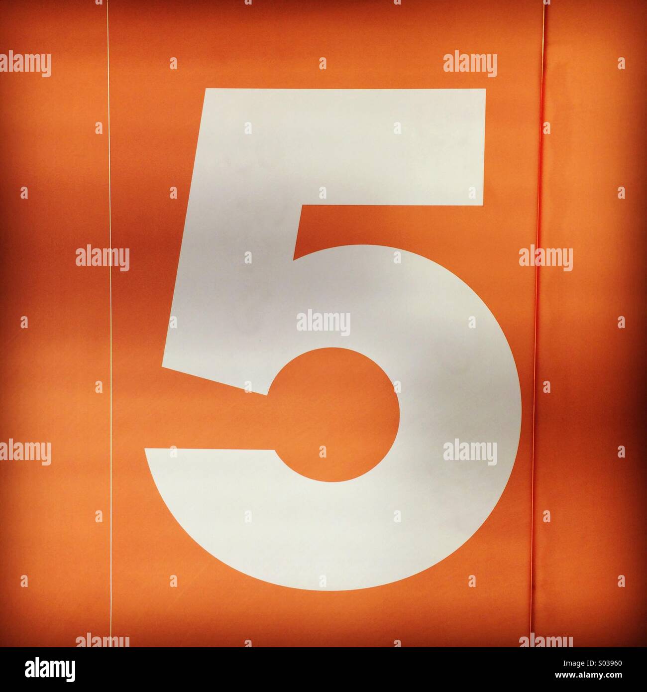 Numero bianco cinque numero di pavimento su uno sfondo arancione. Foto Stock