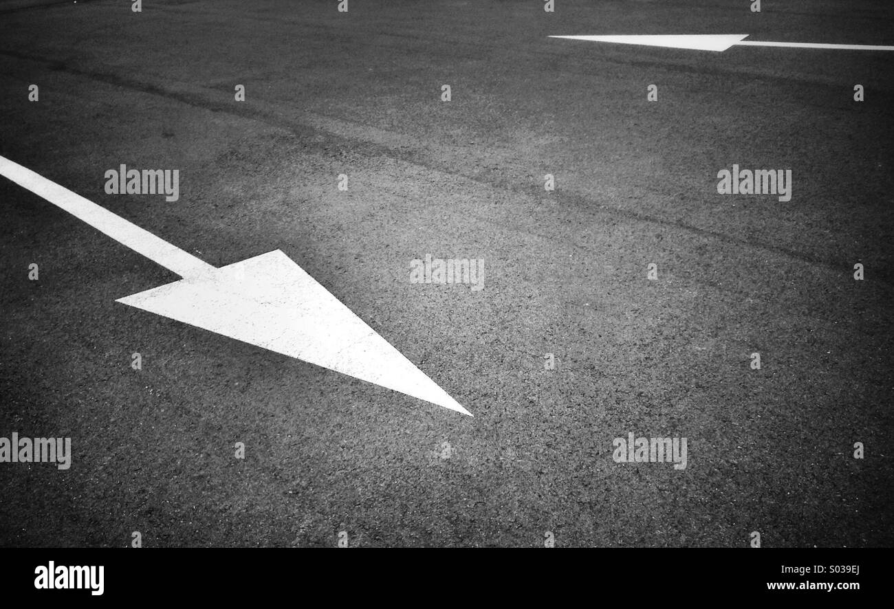 Dipinto di bianco opposto segno di freccia su asfalto - Immagine stock catturata con smartphone