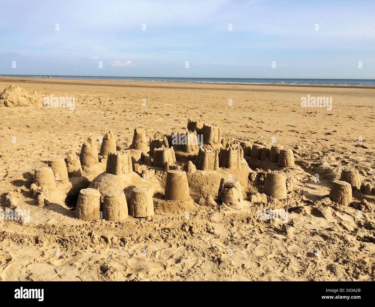 Castello di sabbia sulla spiaggia deserta Foto Stock