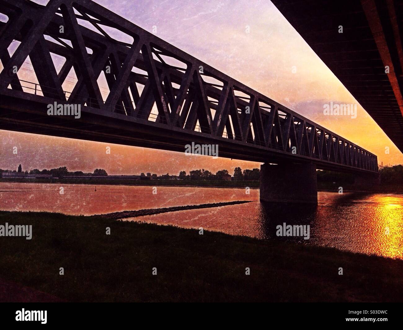 Il ponte ferroviario e il ponte stradale sul fiume Reno al tramonto Foto Stock