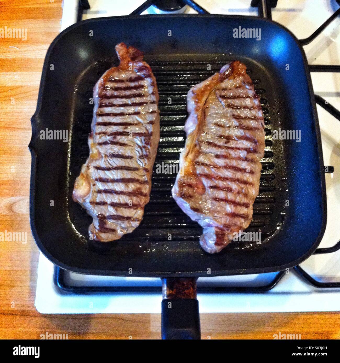 Bistecche di filetto di cottura su una piastra pan - Immagine stock catturata con smartphone