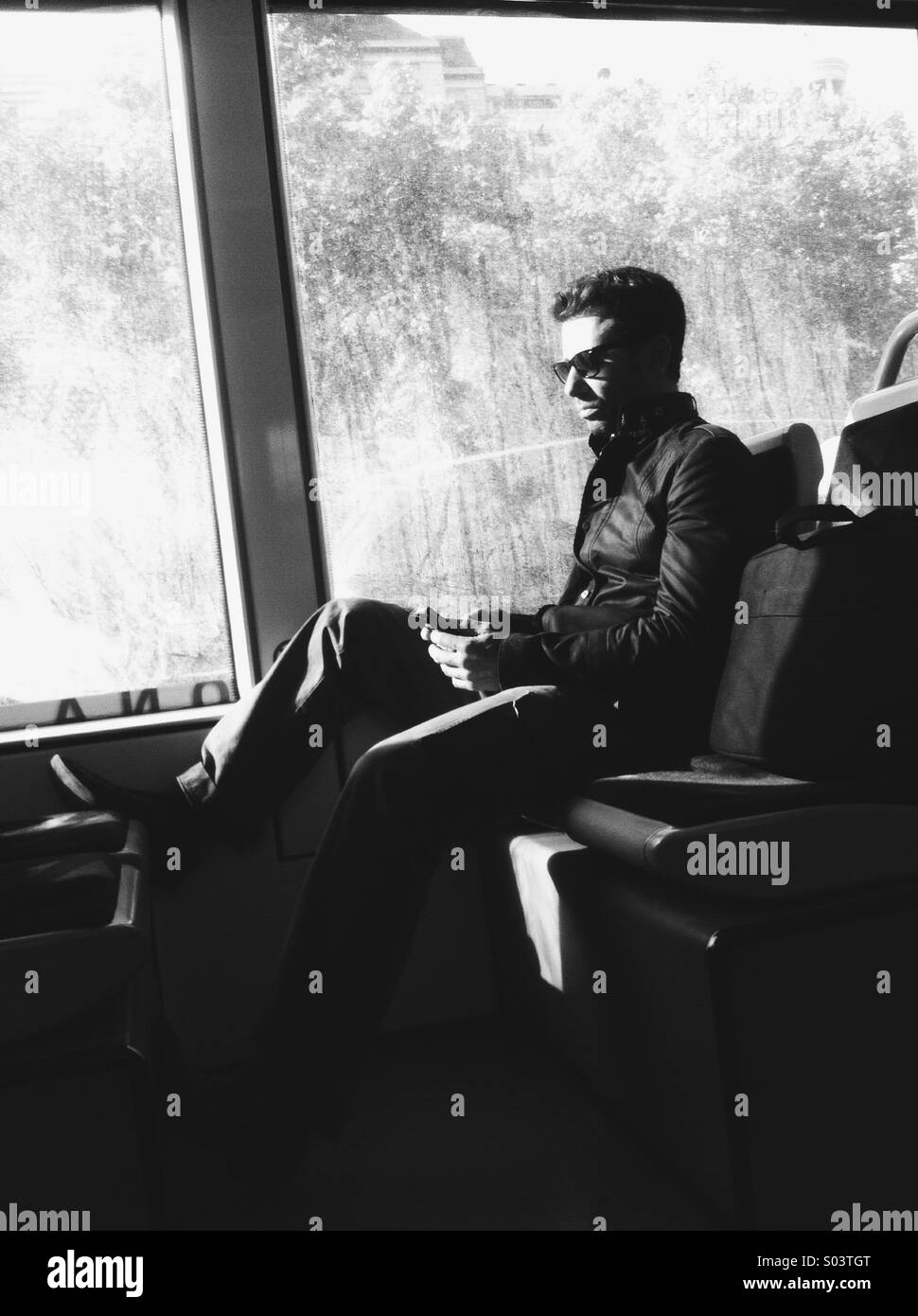Uomo in un treno guardando il suo smartphone Foto Stock
