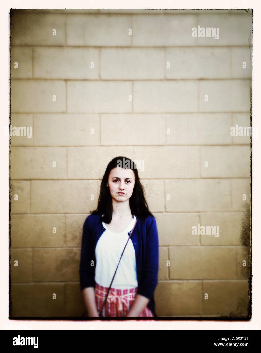 Ragazza adolescente shopping nella parte anteriore del blocco di muro Foto Stock