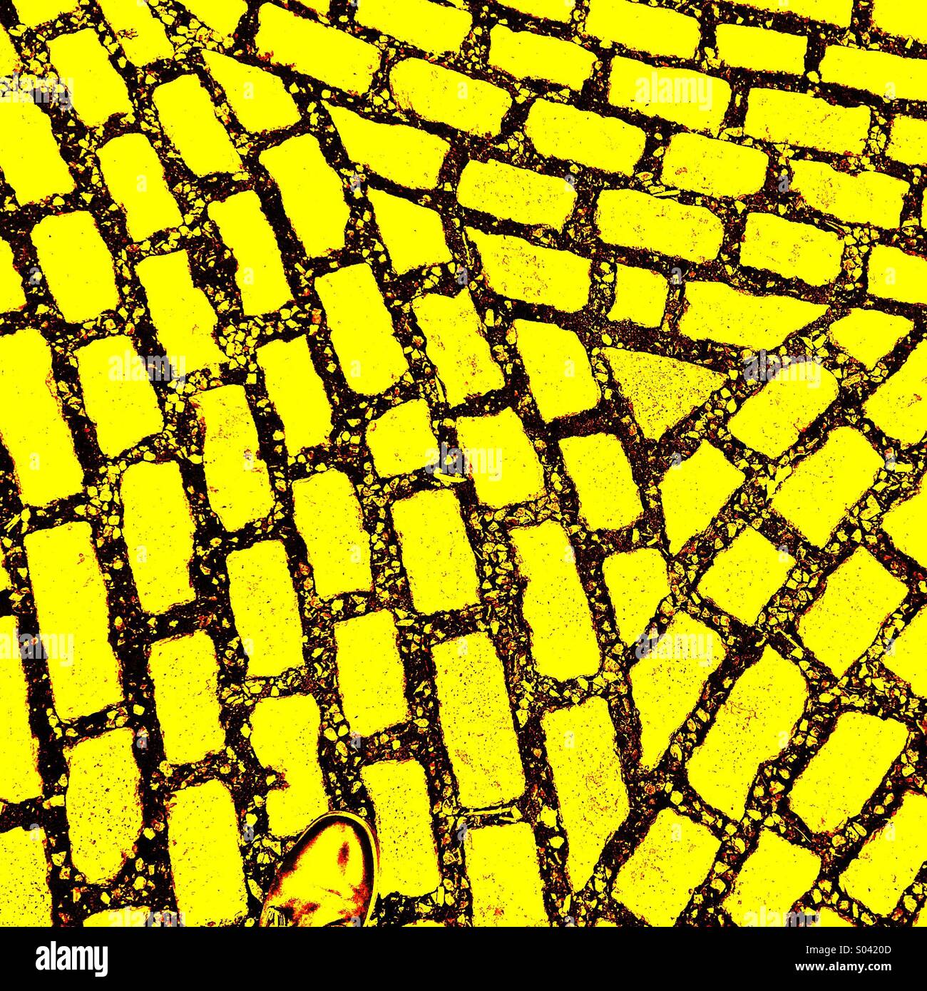 Un piede sul mattone giallo road Foto Stock