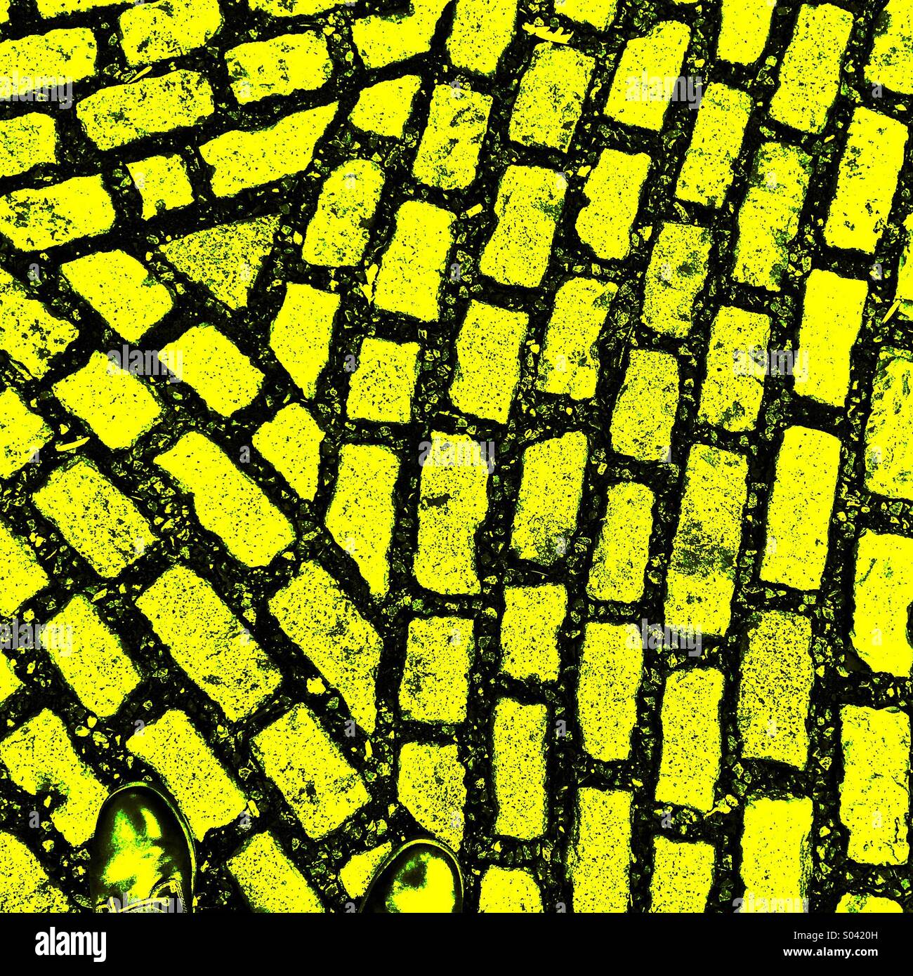 Due piedi sul mattone giallo road Foto Stock