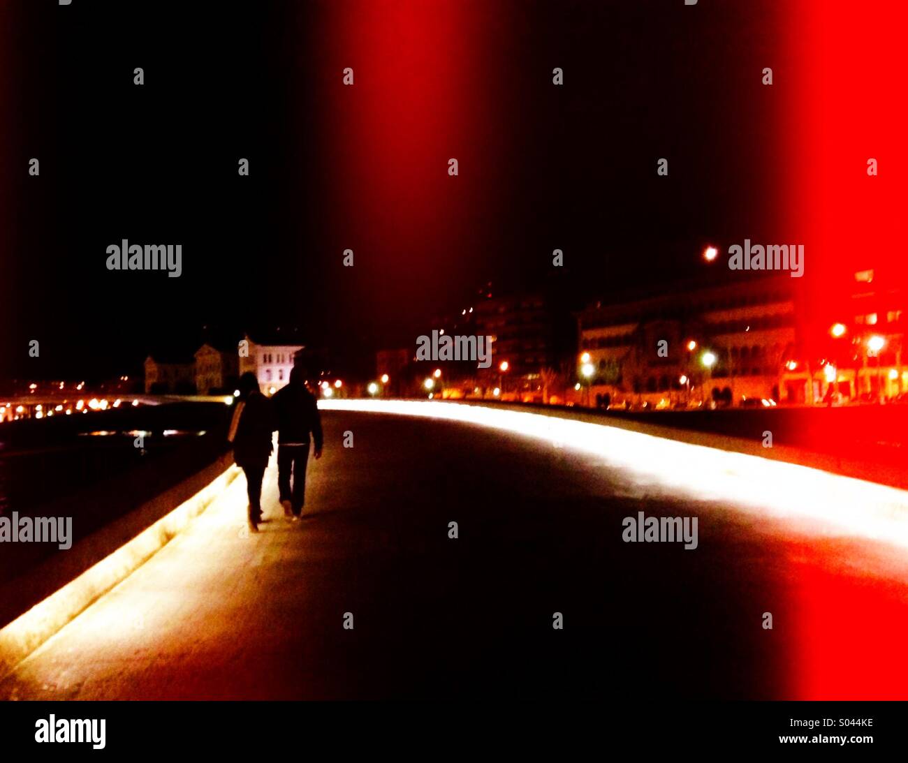 Giovane attraversando un ponte di notte Foto Stock