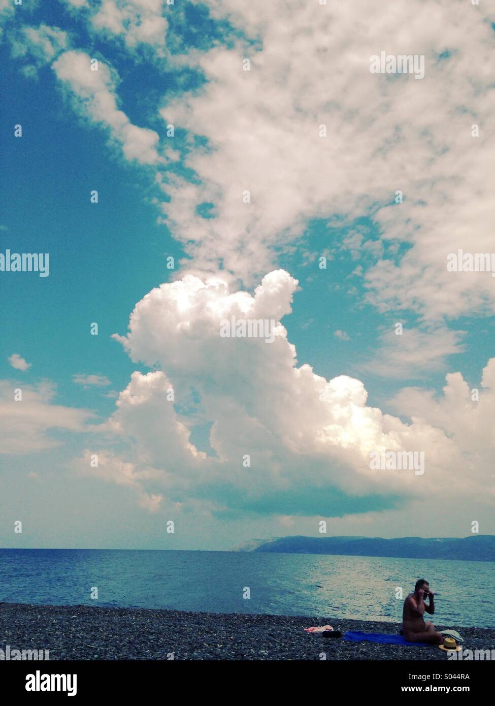 Lone bagnante su una spiaggia con drammatica nuvole in background Foto Stock