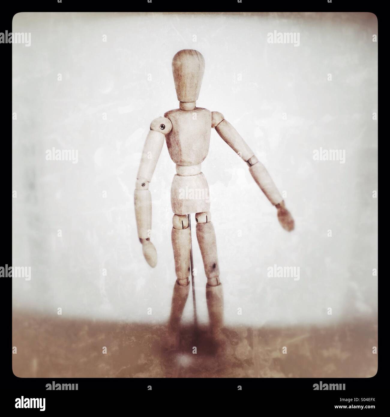 Il manichino dell'artista in legno ha posato in un ambiente artistico con sfondo neutro - Immagine stock catturata con smartphone