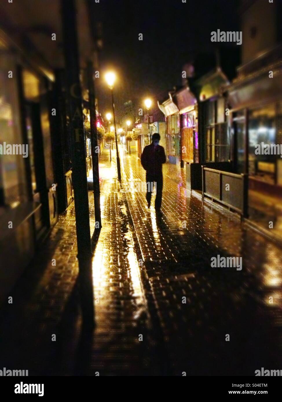 A profilarsi la figura passeggiate attraverso il nord Laines, BRIGHTON REGNO UNITO su una serata piovosa. Foto Stock