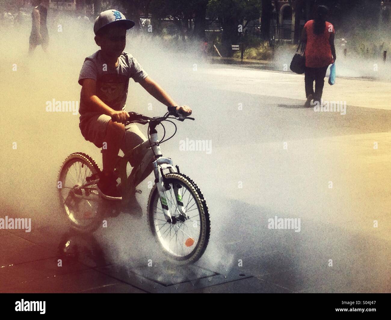 Ragazzo su una bicicletta nella nebbia Foto Stock