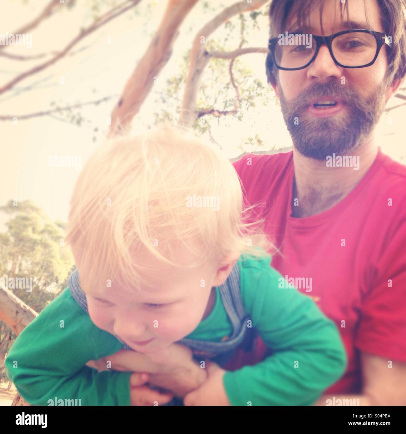 Uomo con barba holding bambino biondo Foto Stock