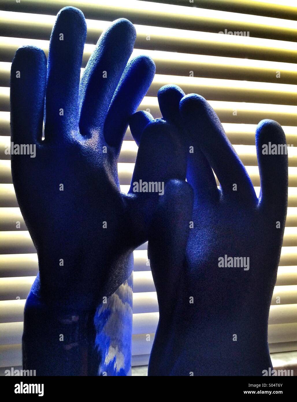 Un immagine astratta di due blu guanti di gomma contro un sfondo a strisce Foto Stock