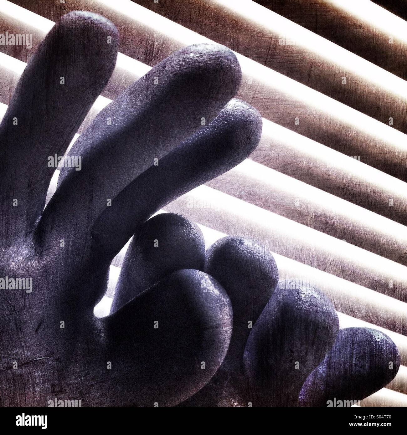 Un abstract immagine artistica delle dita di due guanti di gomma contro un sfondo a strisce Foto Stock