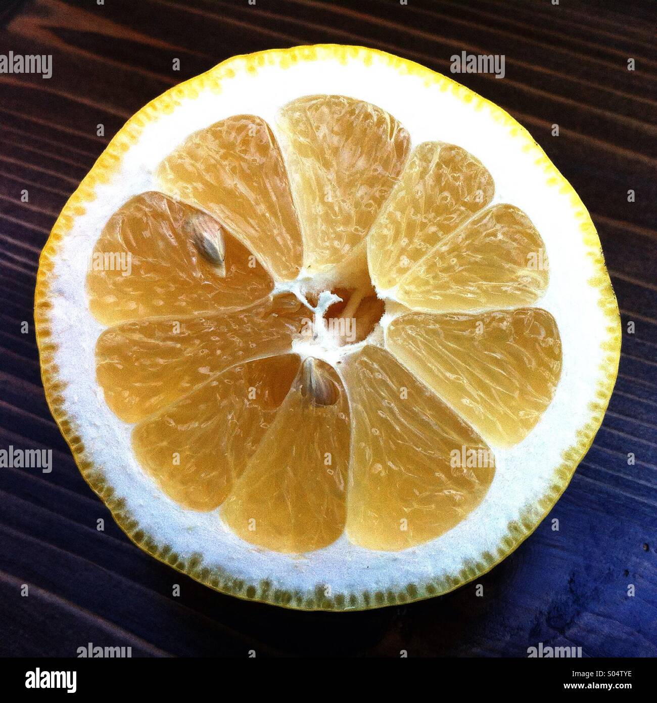 Tagliate a fette di limone a metà su una superficie di legno. Foto Stock