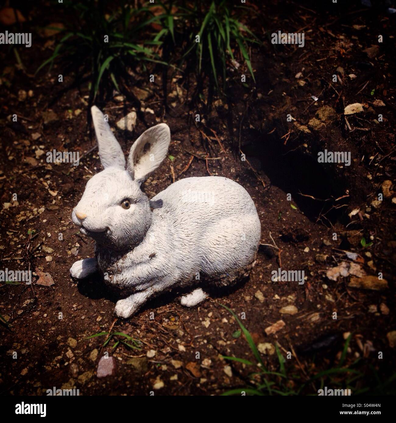 Una scultura di un coniglio bianco nel foro di coniglio decora un sentiero turisti in Peña de Bernal, Stato di Queretaro, Messico - Immagine stock catturata con smartphone
