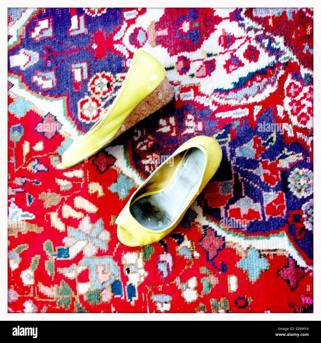 Scarpe di colore giallo su un vivacemente colorato tappeto orientale Foto Stock