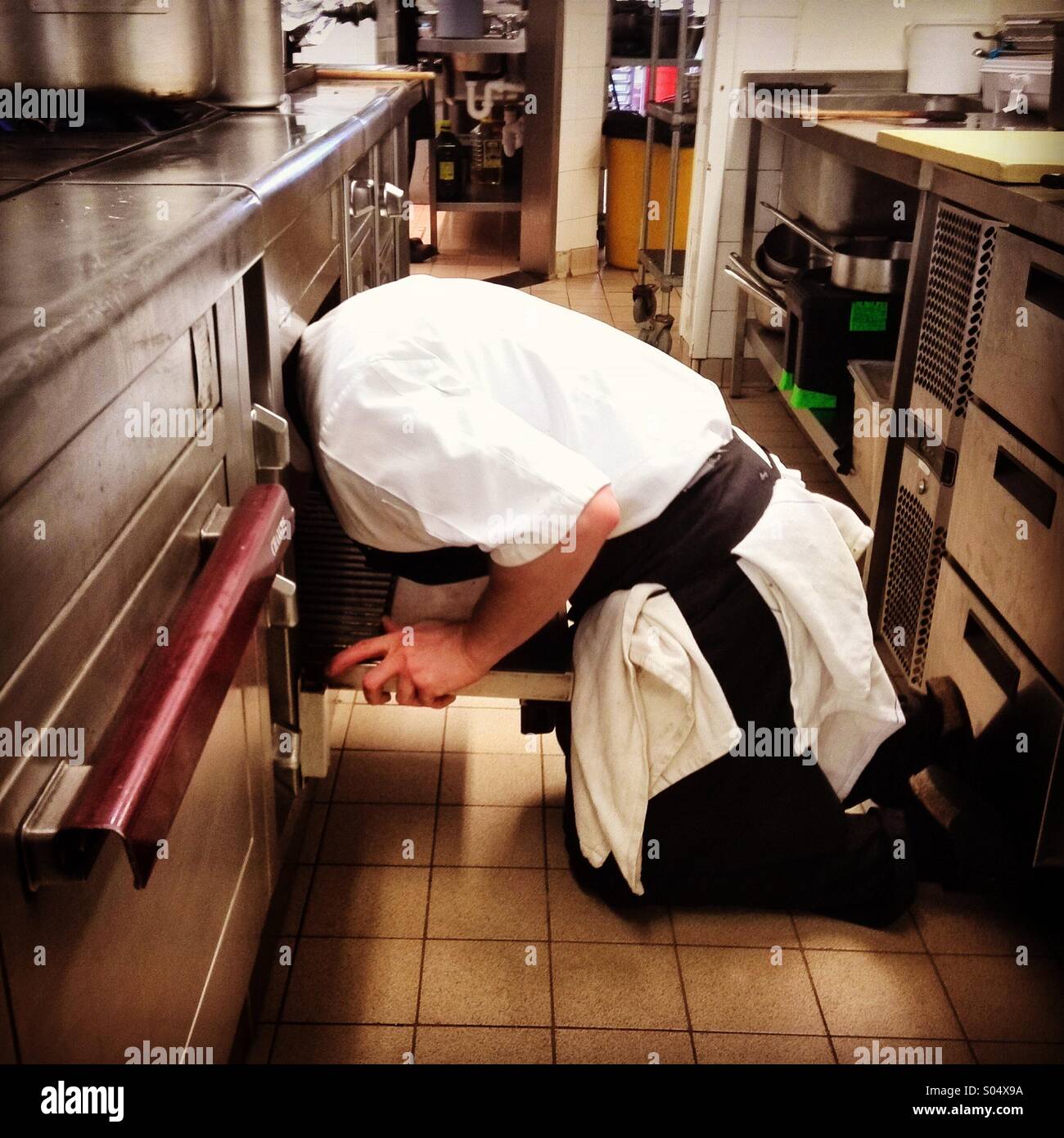 Lo chef con la sua testa in un forno, pulizia Foto Stock