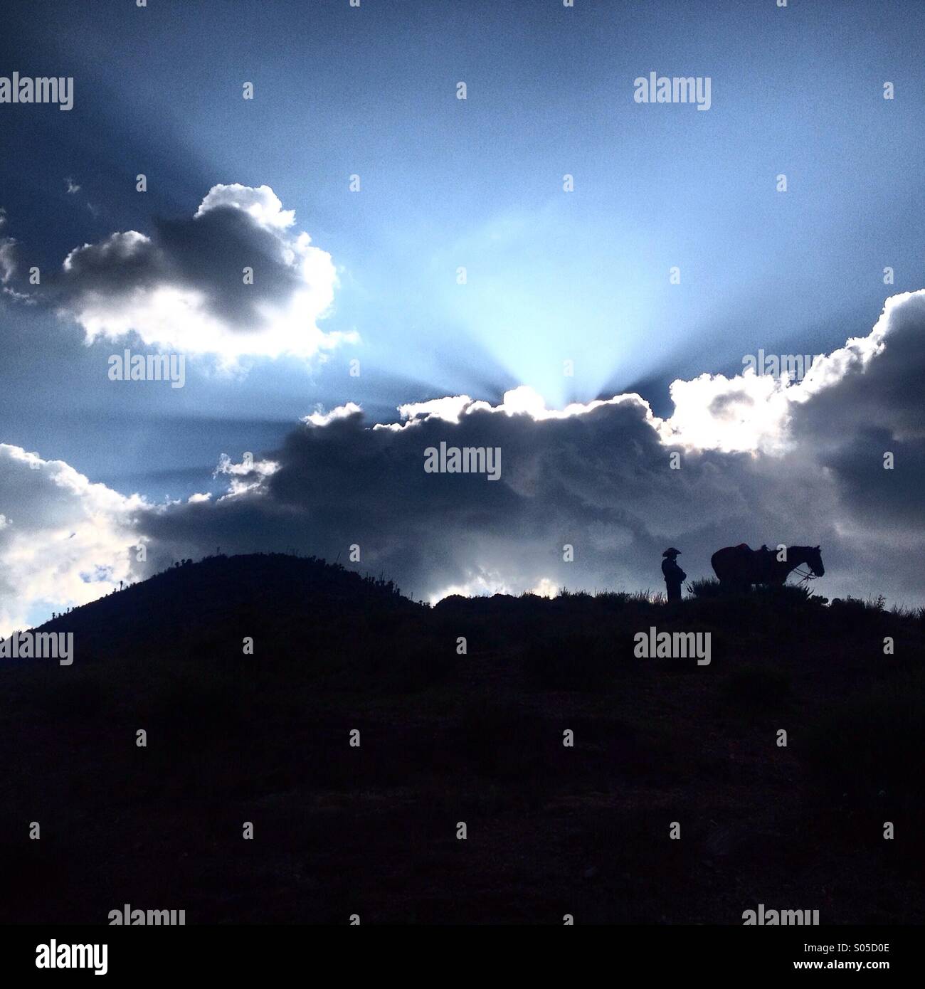Un cowboy messicano e il suo cavallo stand in Cerro Quemado montagna in Wirikuta, un sacro deserto per Wirarika o indigeni Huichol vicino a Real de Catorce, San Luis Potosi, Messico - Immagine stock catturata con smartphone