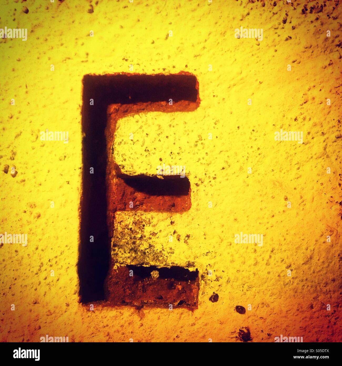 Una lettera E in una parete gialla in Guanajuato, Messico Foto Stock