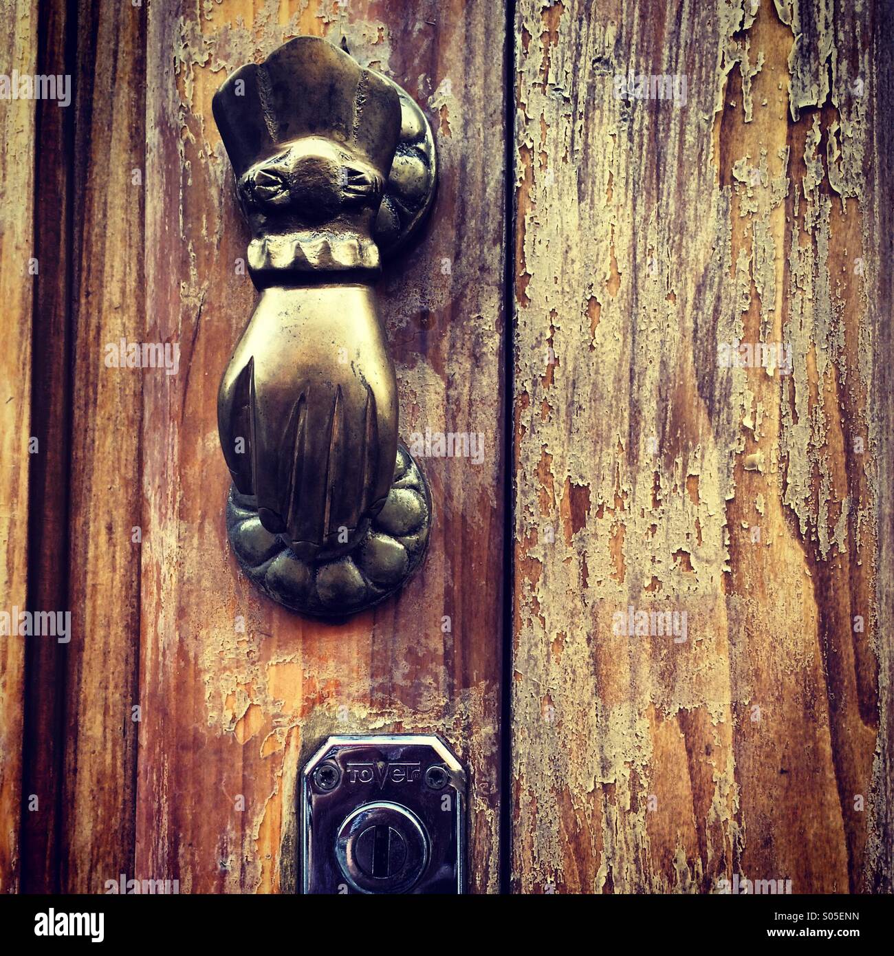 Una vecchia porta di legno con un ottone coloniale mano come un battito Foto Stock