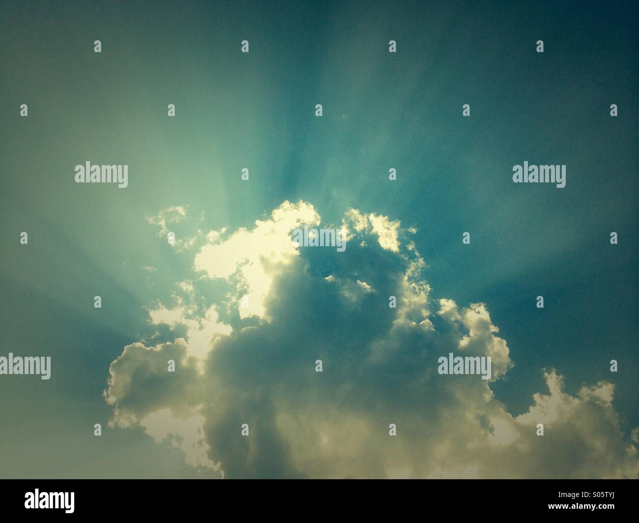 Raggi di sole da dietro una nuvola. Foto Stock