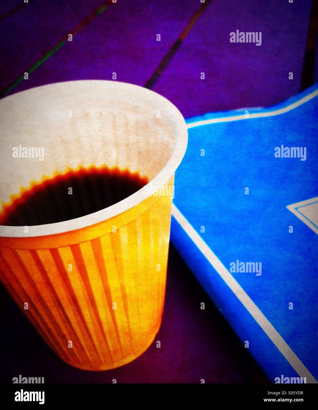 Una tazza di caffè e un notebook blu Foto Stock