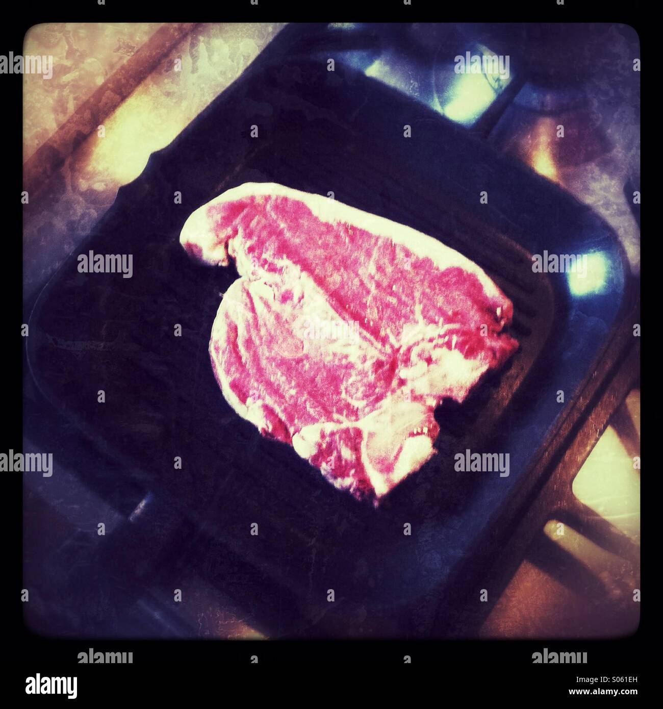 T-bone steak cottura su una piastra pan - Immagine stock catturata con smartphone