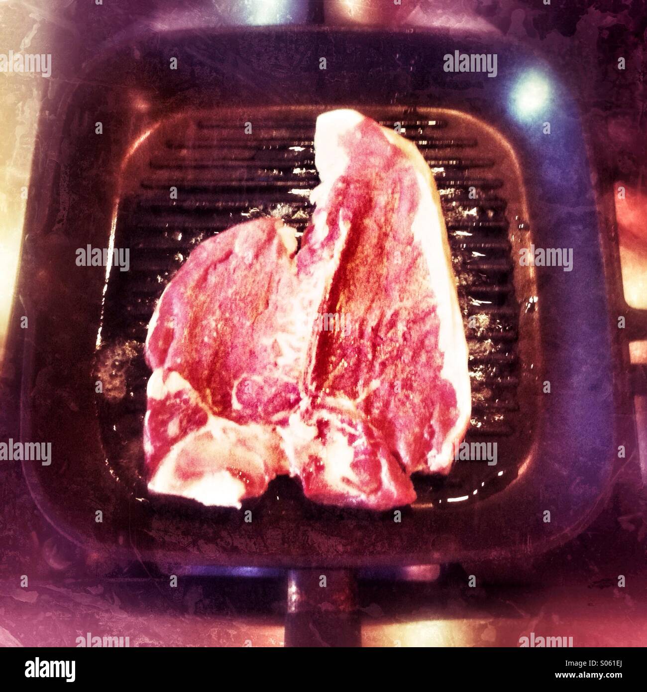 T-bone steak cottura su una piastra pan - Immagine stock catturata con smartphone