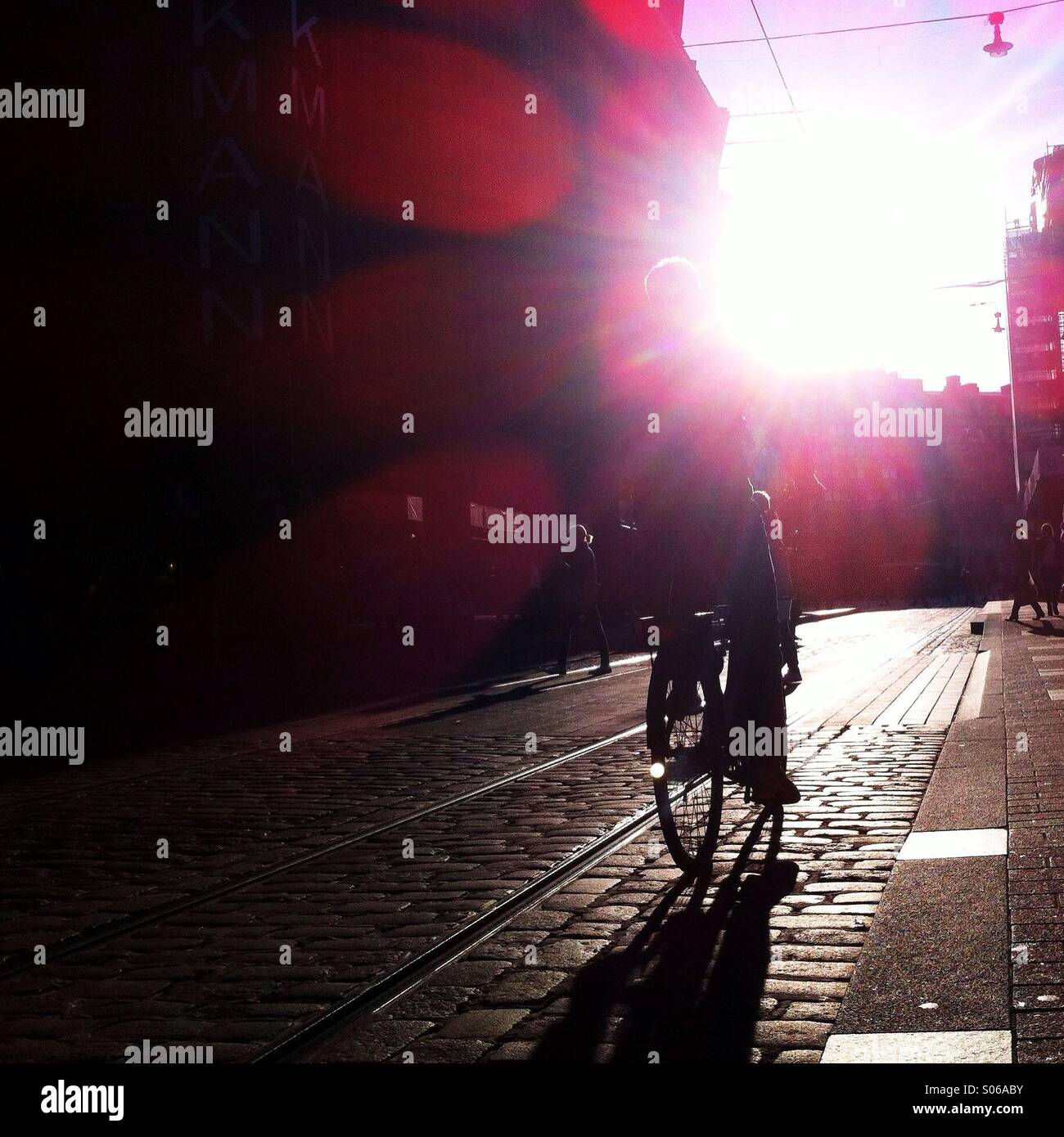 Un ciclista contro la luce solare nel centro di Helsinki Foto Stock