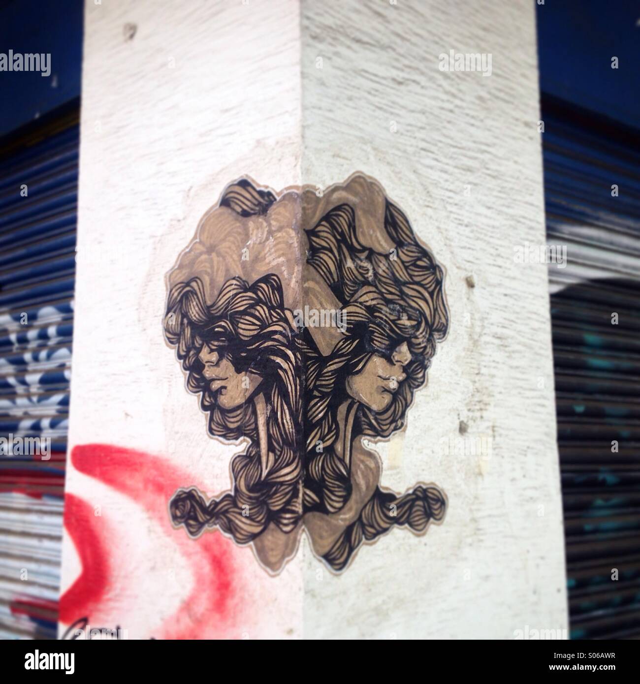 Un adesivo che mostra due volte il volto di una donna decora un angolo in Colonia Condesa en Città del Messico, Messico - Immagine stock catturata con smartphone