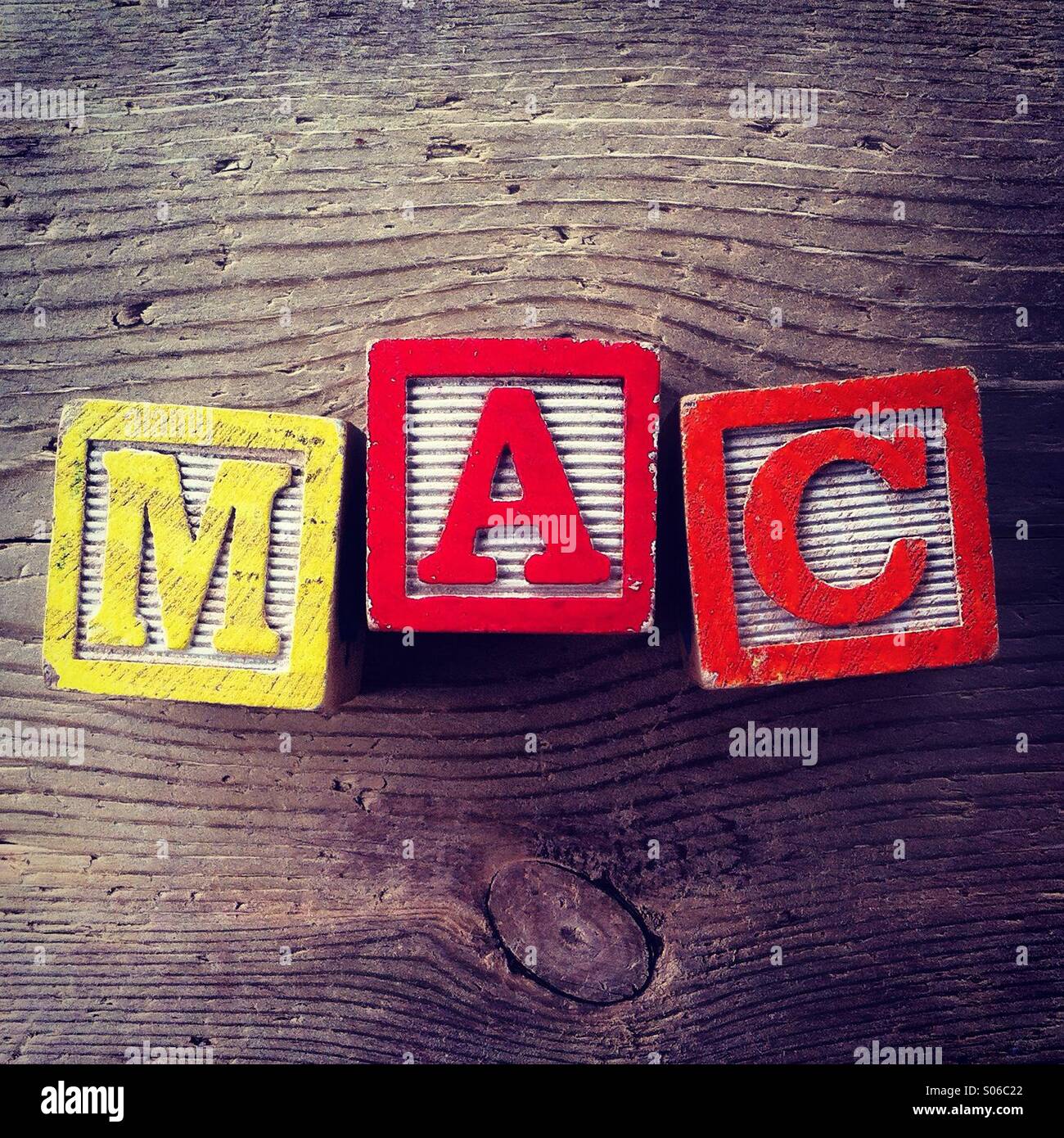 Si tratta di una foto di tavolette di legno giocattolo giochi con alfabeto lettere su di loro che si uniscono per formare la parola MAC - Immagine stock catturata con smartphone