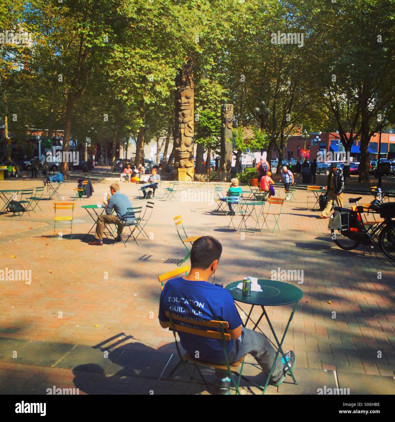 Seduti all'aperto, Occidental Park, Pioneer Square Historic District, Seattle Foto Stock