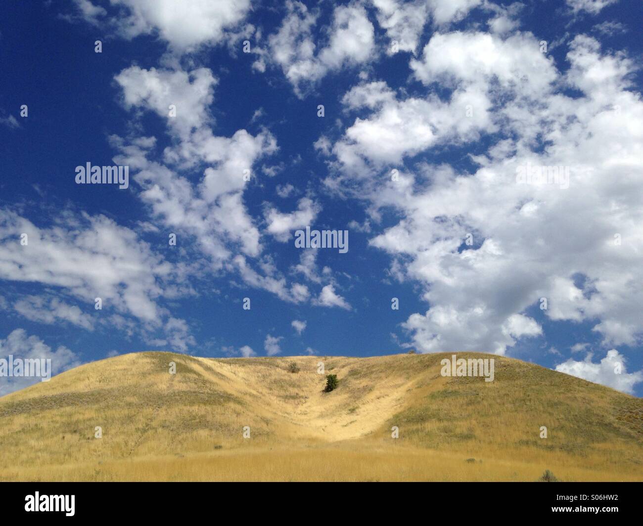 Cielo blu e nuvole whispy sopra le colline lungo la Wasatch una montagna di Salt Lake City, UT. Foto Stock
