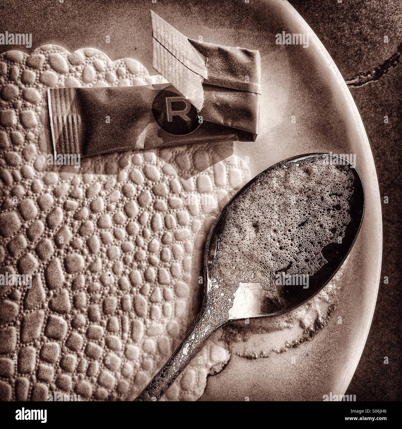 Cucchiaino da caffè con la schiuma, vuota bustina di zucchero - Immagine stock catturata con smartphone