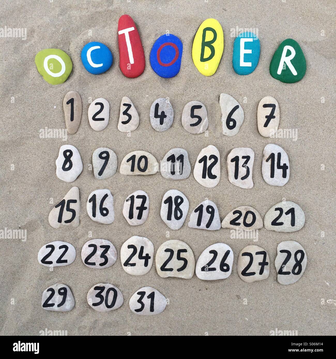 Ottobre mese del calendario con composizione di pietre sulla sabbia Foto Stock