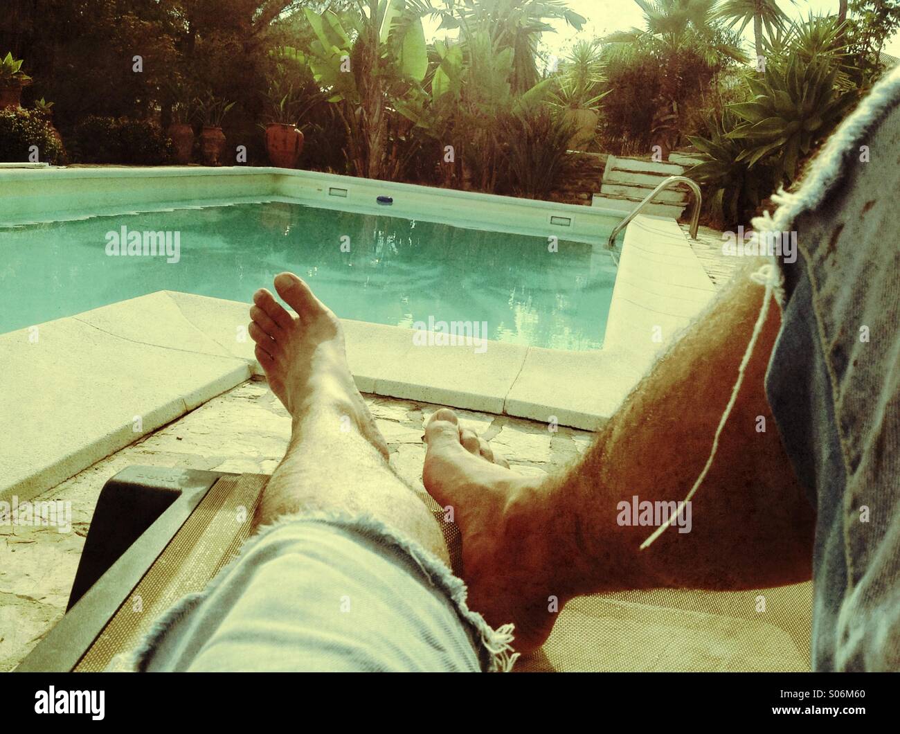 Uomo disteso sul lettino vicino alla piscina Foto Stock