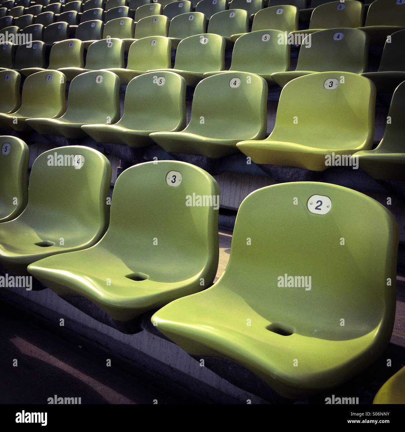 Riga vuota di sedi di verde a uno sport stadium Foto Stock