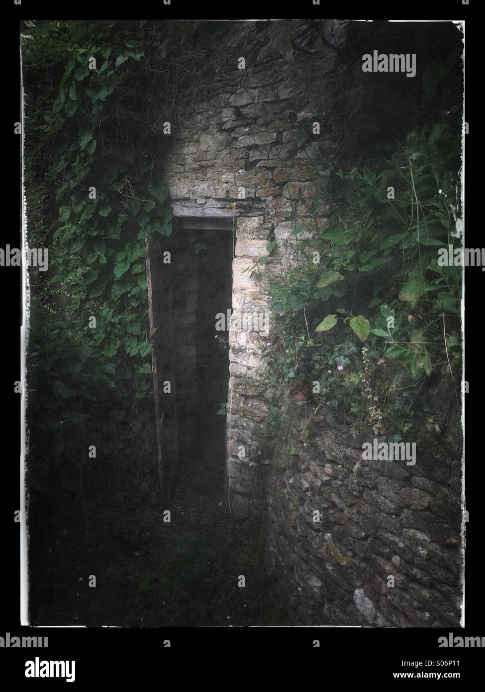 Porta aperta spettrale di un vecchio edificio in pietra Foto Stock