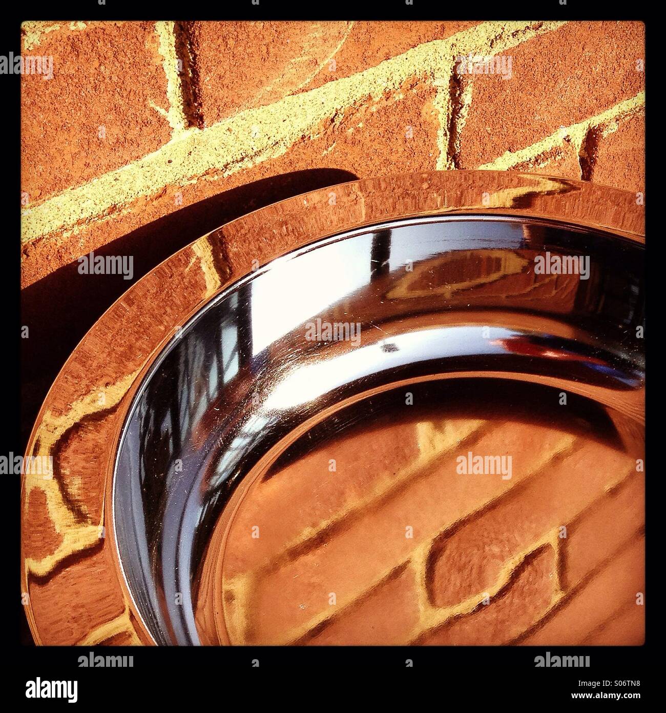 Abstract di terracotta la muratura di mattoni si riflette nel bacino di cromo. Foto Stock