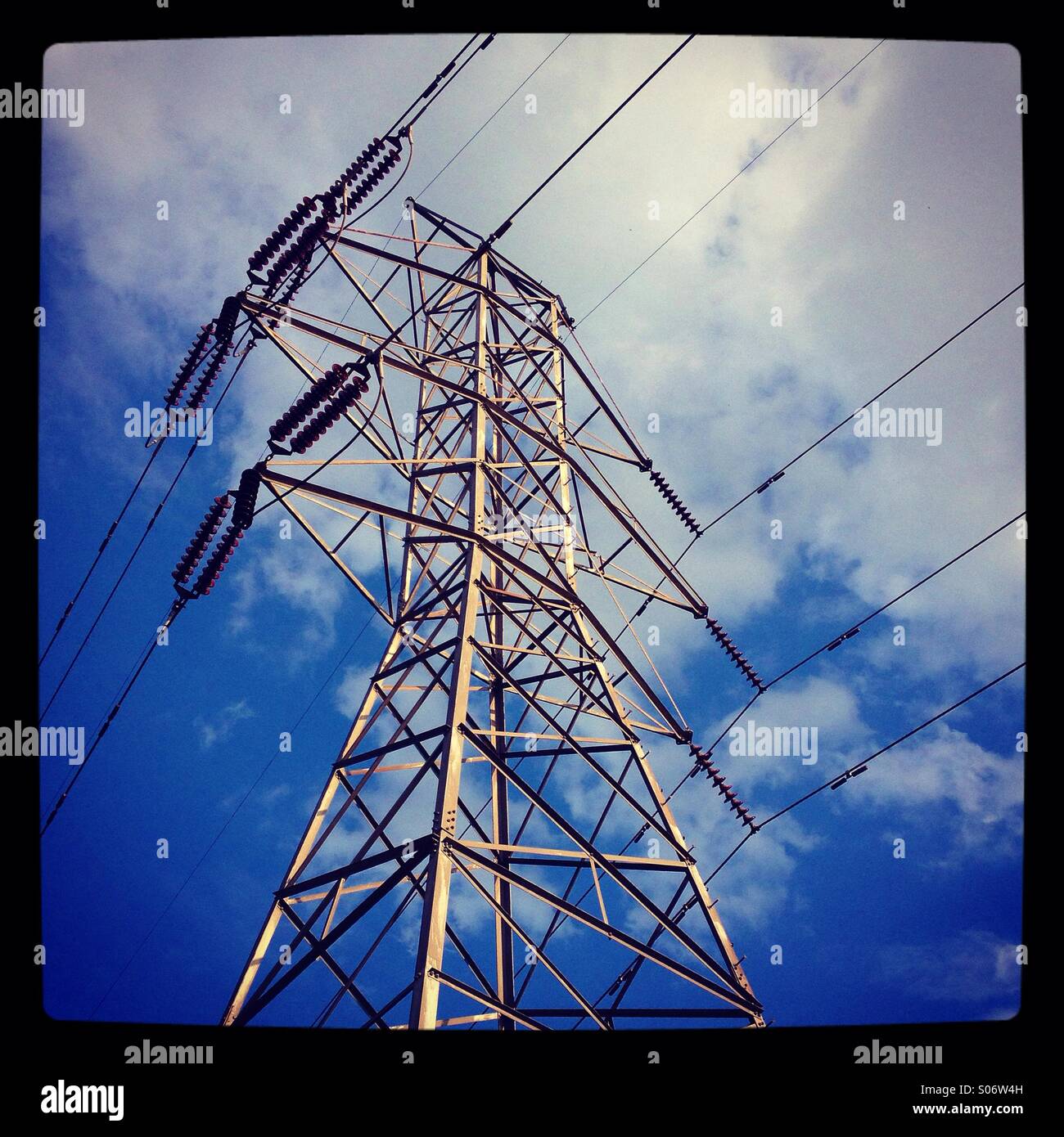 Linee elettriche ad alta tensione contro una brillante nube blu cielo pieno. Foto Stock