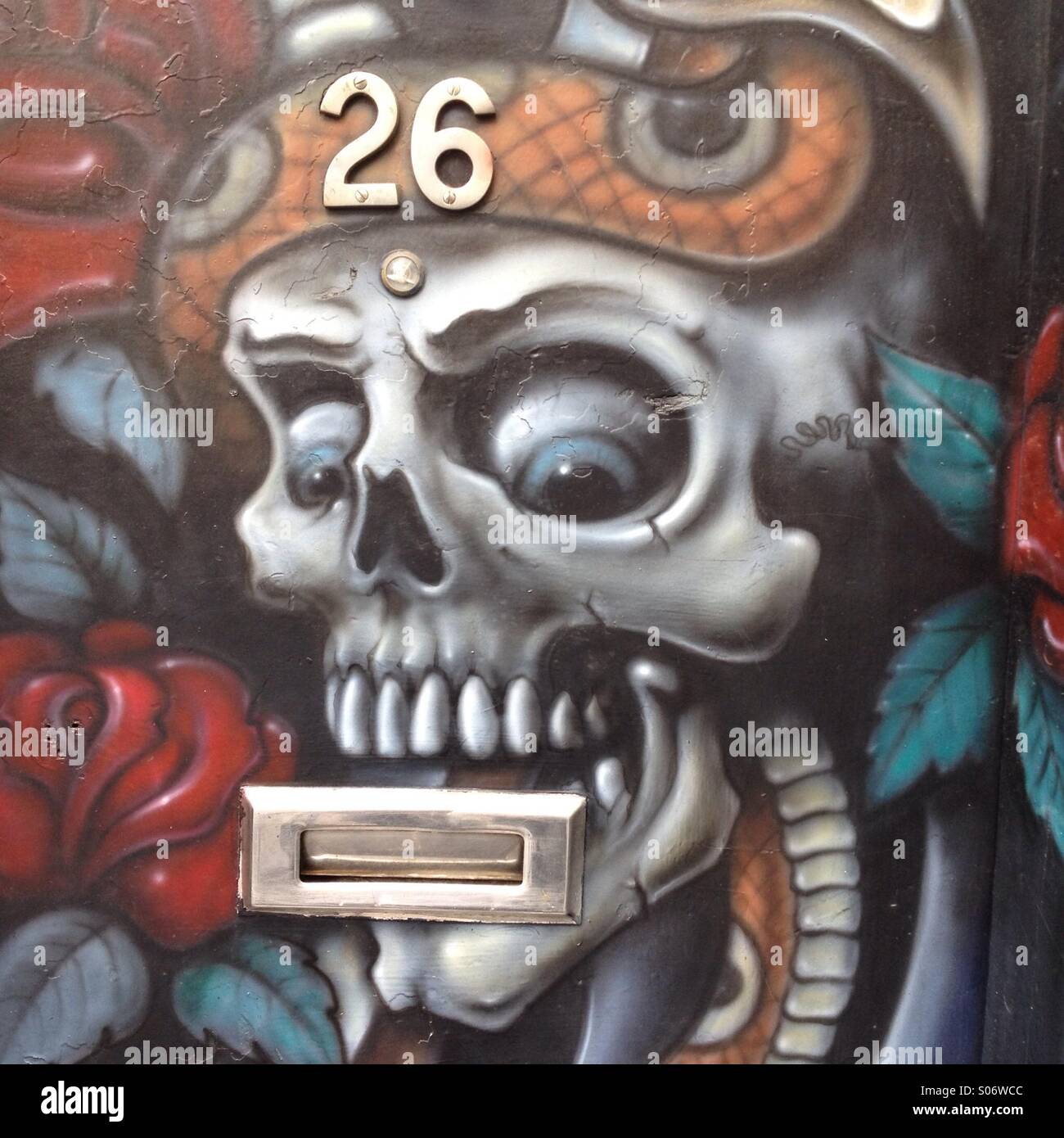 Primo piano dell'opera d'arte Graffiti sulla porta d'ingresso di un salotto di tatuaggi a Camden Town, Londra - Immagine stock catturata con smartphone