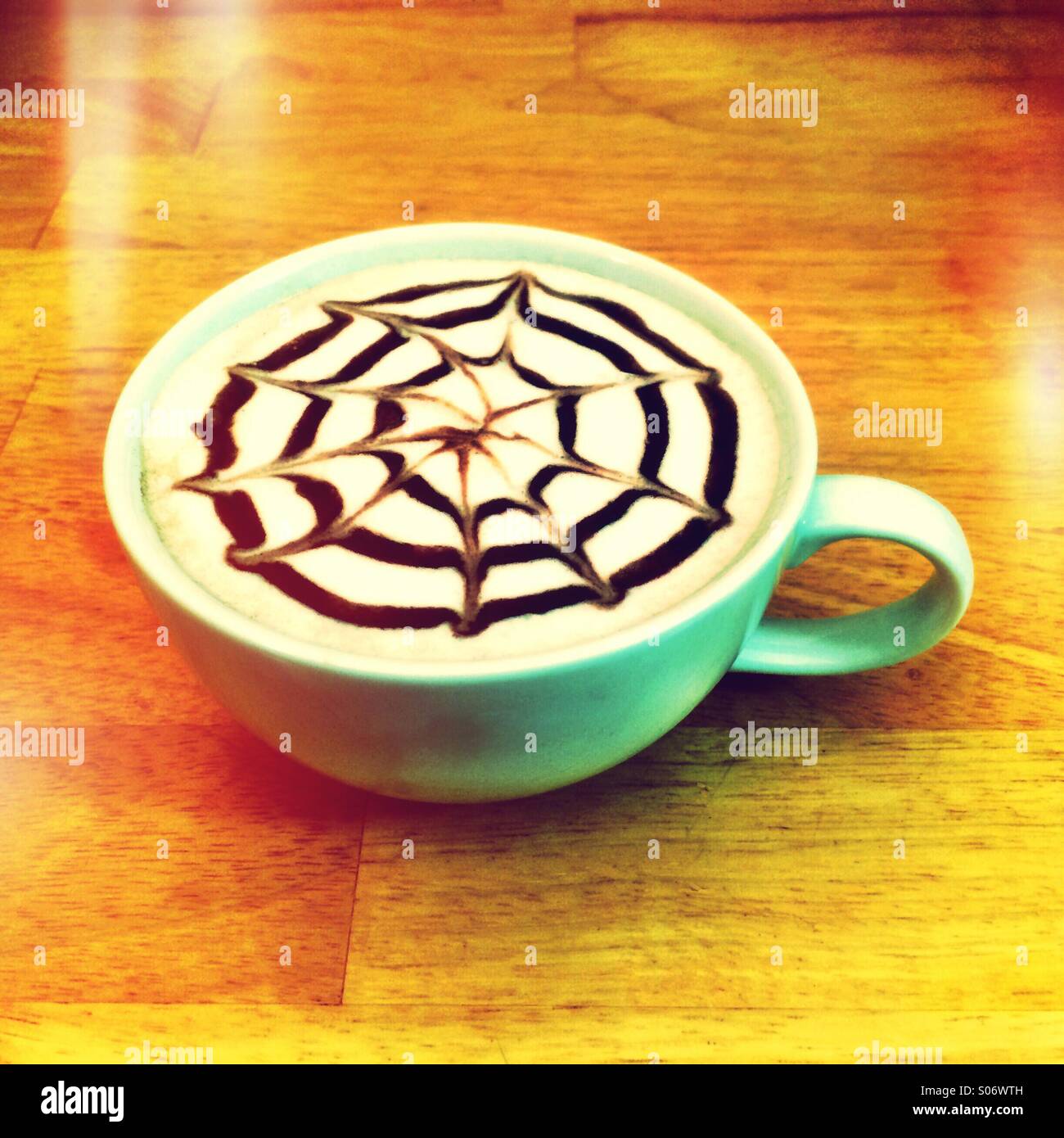 Latte caffè con un design in sciroppo al cioccolato sulla parte superiore. Foto Stock