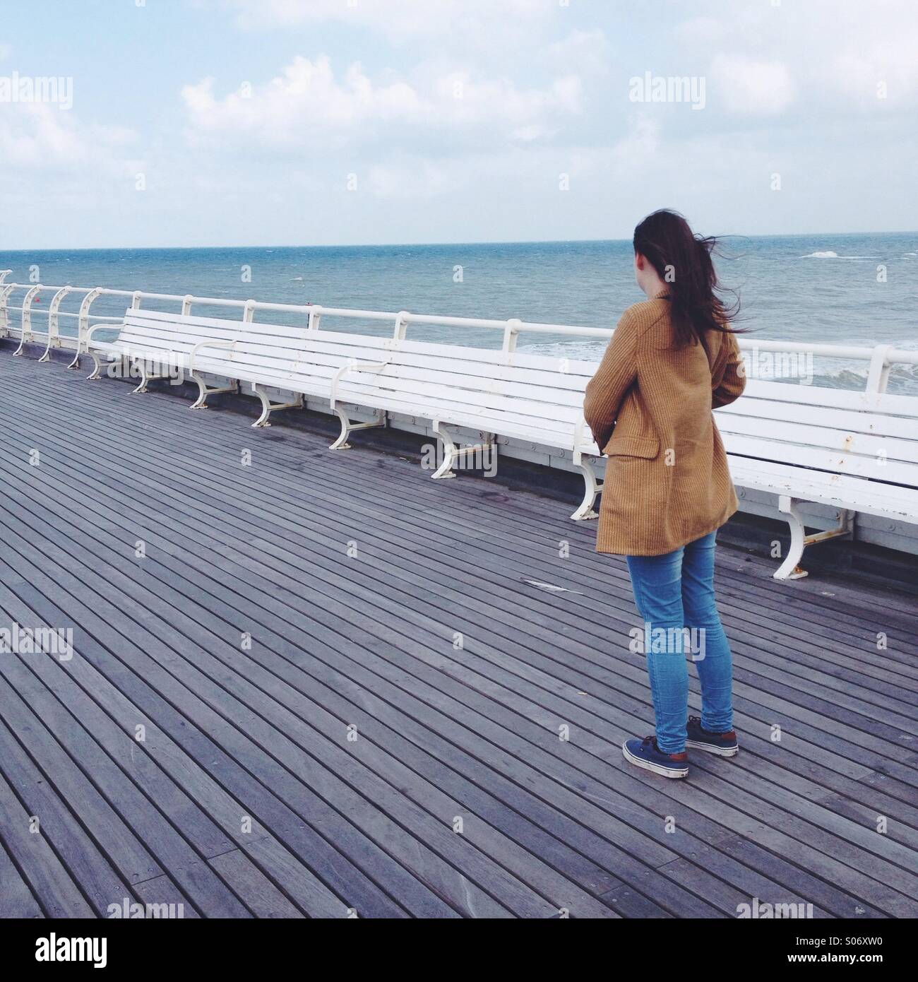 Signora in piedi da solo sul molo Foto Stock