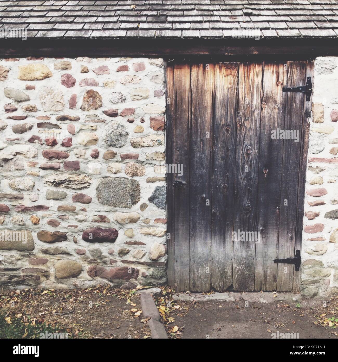 Ciottolo fienile con porta in legno e tetto Foto Stock