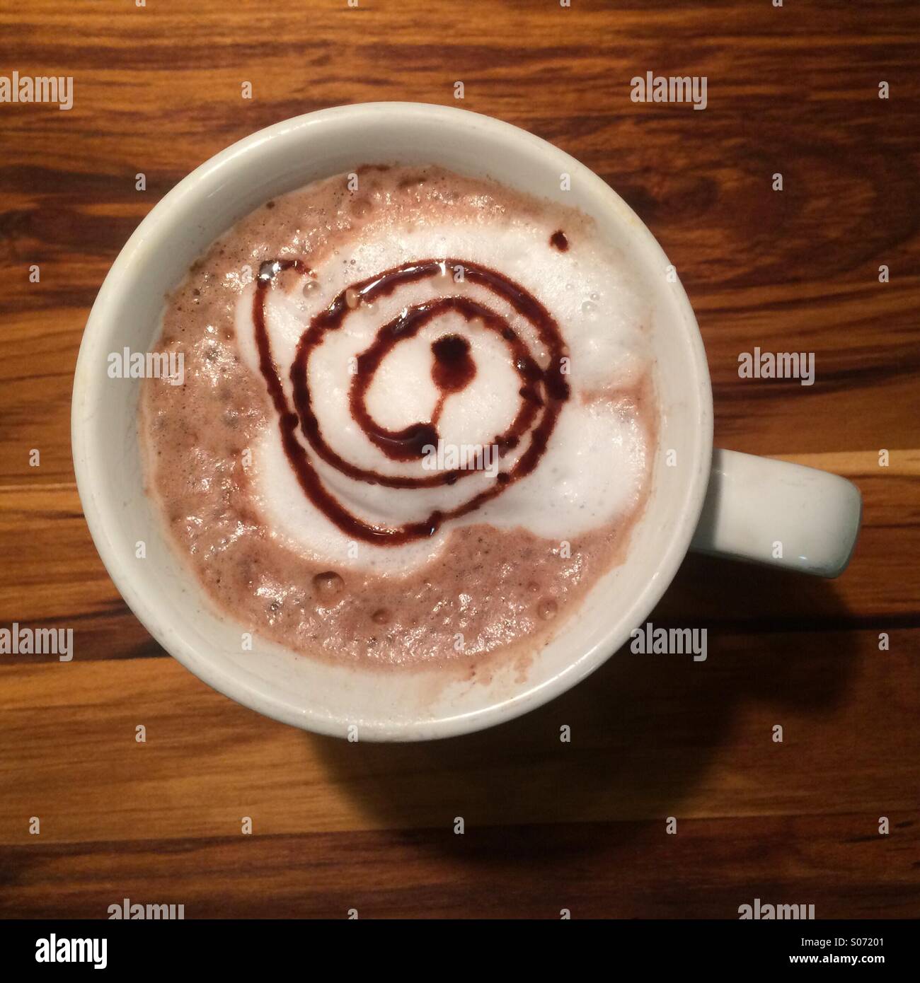 Cioccolata calda bevanda con lo sciroppo al cioccolato swirl. Foto Stock