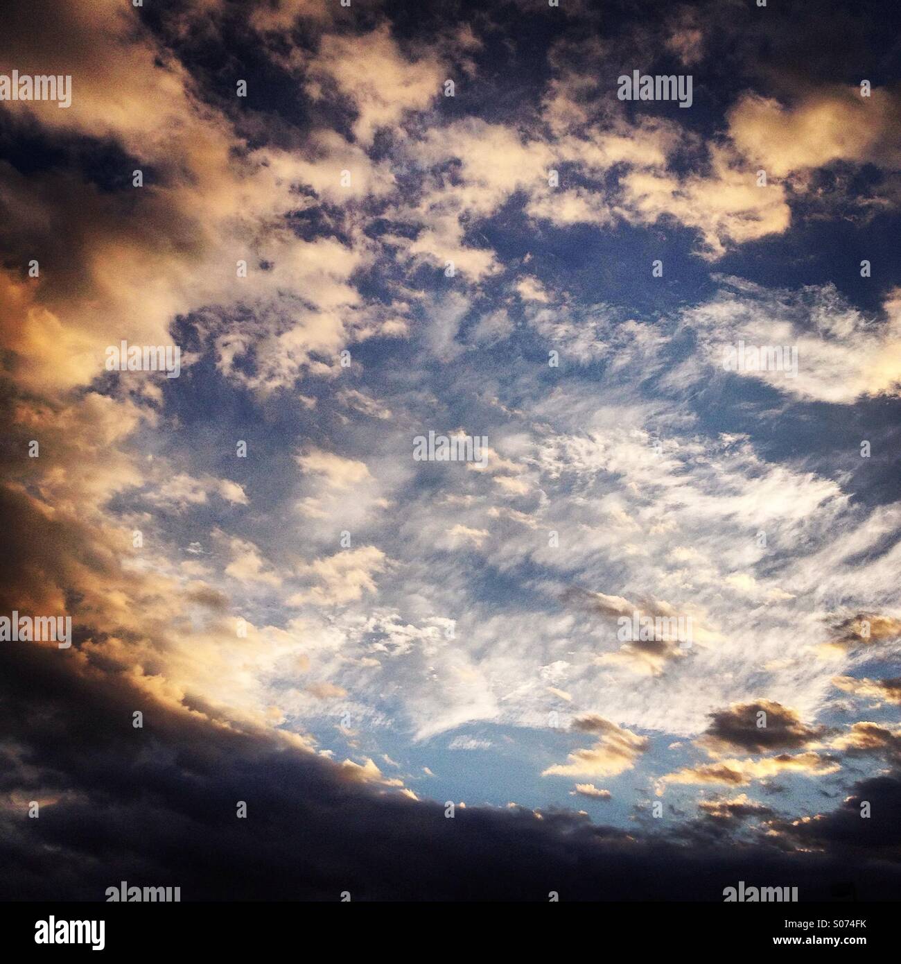 Cielo drammatico con un imminente tempesta il cuscinetto verso il basso a partire da sinistra sul cielo blu con luminose nuvole bianche in centro. Foto Stock
