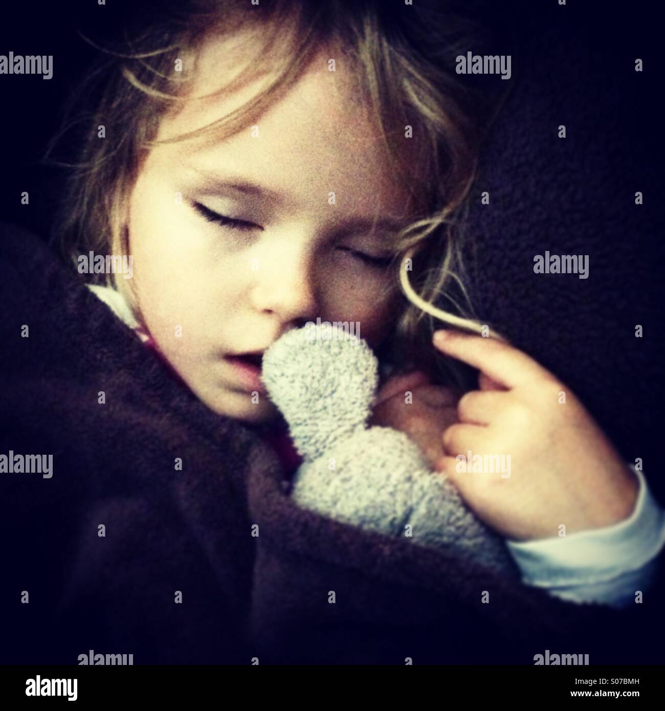 Giovane ragazza bambino addormentato con il suo giocattolo di peluche Foto Stock